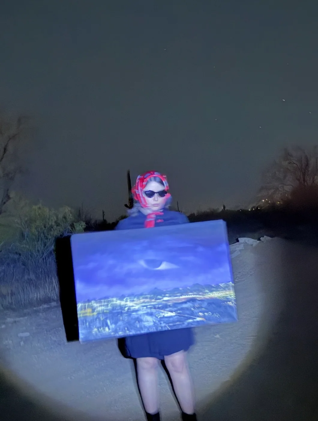 Anna Douglas at night, holding a painting